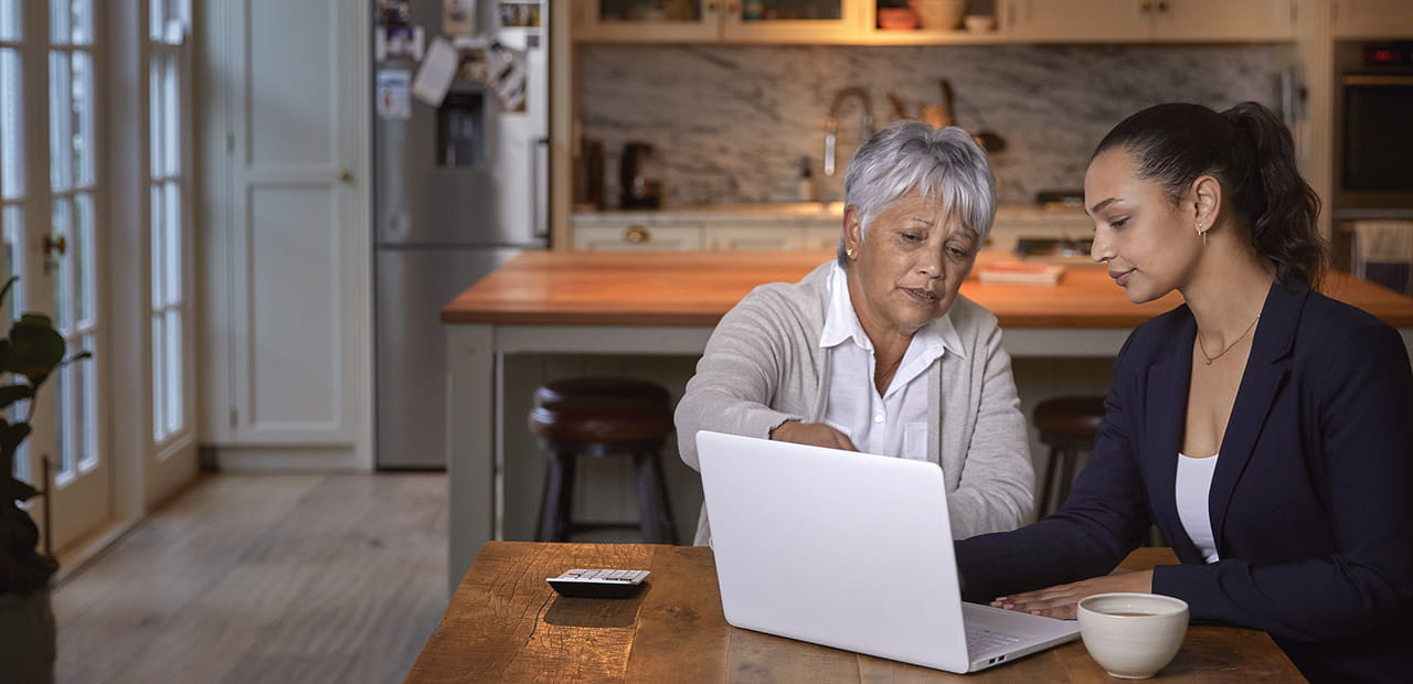 Senior woman having a consultation with a female financial advisor at home.